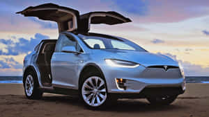 銀色 Tesla Model X 在日落沙灘上打開車門。