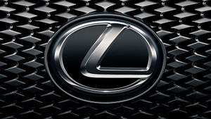 黑色紋理汽車格柵上的鍍鉻 Lexus 徽章。