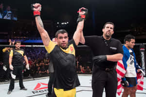 UFC拳手在八角籠中高舉雙臂慶祝勝利。 — 運動 壁紙