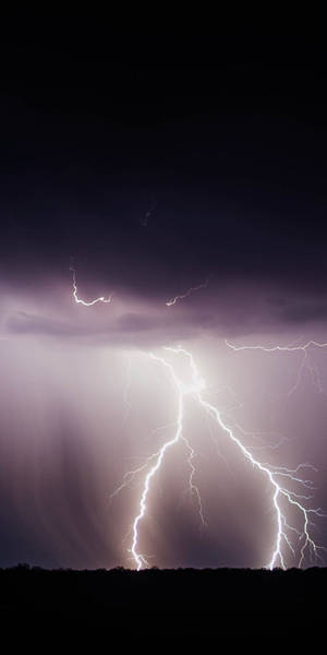 強烈的閃電劃破黑暗暴風雨的天空，上方是黑色的地平線。