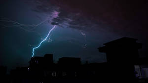 閃電擊中夜晚黑暗的城市屋頂。