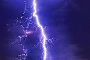 強烈的閃電照亮了黑暗的暴風雨天空，帶有電光紫色調。