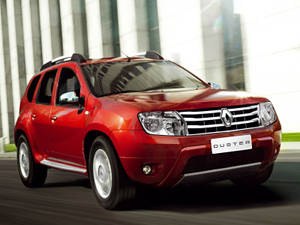 紅色雷諾 Duster SUV 駛過現代玻璃建築。