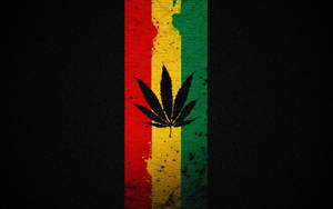 黑色大麻葉在紅、黃、綠條紋上，背景為深色紋理。