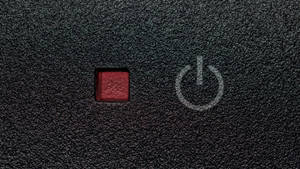 黑色紋理表面上的紅色電源按鈕，帶有白色電源符號。 — 黑色動態圖 壁紙
