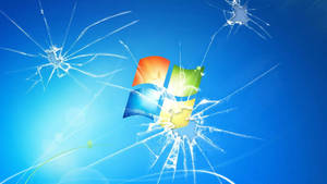 破碎的玻璃在藍色背景上顯露出色彩繽紛的 Windows 標誌。 — 視窗 壁紙