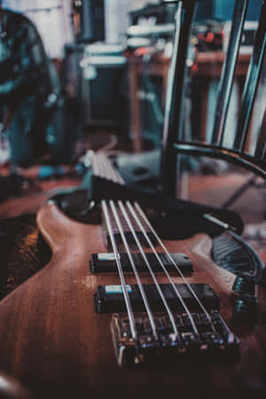 一把木製低音結他放在音樂工作室的椅子上，光線柔和。