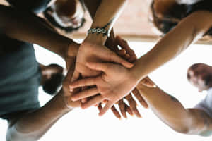 不同人士堆疊的手象徵團隊合作與團結。