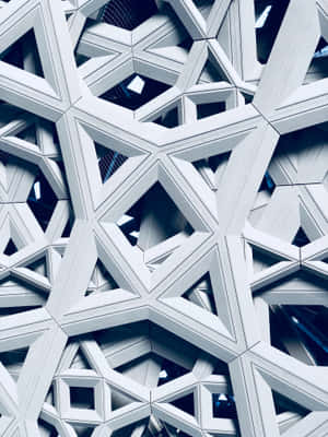 白色幾何建築圖案嘅特寫，帶有藍色陰影。