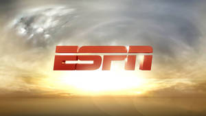 ESPN 標誌漂浮在充滿活力的日落天空上，帶有金色雲彩。