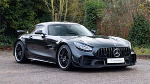 黑色Mercedes-AMG GT Black Series超級跑車停在碎石上，靠近綠色灌木叢。