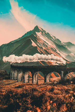 蒸汽火車在石拱橋上，背景有雪山。
