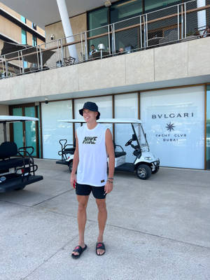 年輕男子在Bulgari Yacht Club前微笑，旁邊有高爾夫球車 — 網球 壁紙
