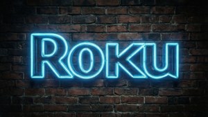 深色磚牆上的藍色霓虹 Roku 標誌