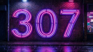 霓虹燈牌307在夜雨中在濕磚牆上發光。