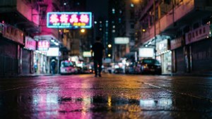 夜晚，一個人在潮濕的城市街道上，在發光的霓虹招牌下獨自行走。 — 香港霓虹燈 壁紙