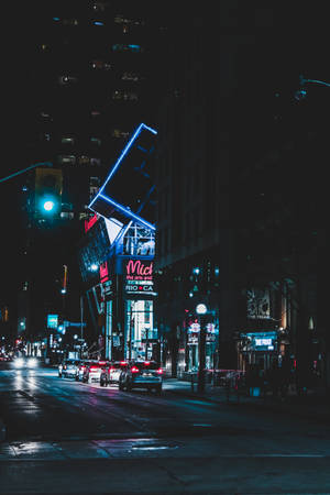 夜晚的城市街道，霓虹燈招牌和潮濕路面反射燈光。