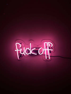 安裝在黑暗牆壁上的粉紅色霓虹燈牌，上面寫著「fuck off」。