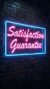 雨夜中，一個寫著 Satisfaction Guarantee 的霓虹燈牌映照在磚牆上。