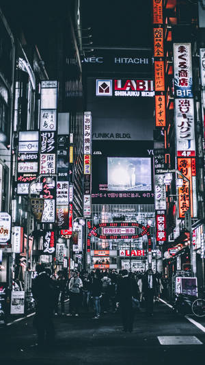 夜晚東京擠滿人群的街道，被發光的霓虹招牌和廣告牌照亮。