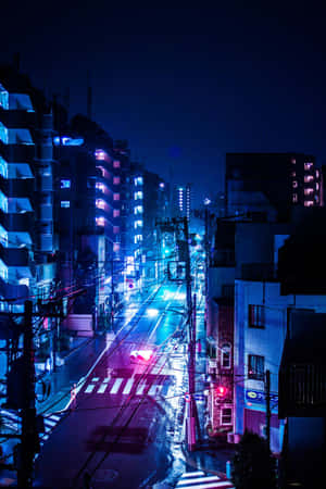 夜晚被霓虹燈照亮嘅城市街道，潮濕嘅路面反射出色彩繽紛嘅燈光。 — 霓虹美學 壁紙
