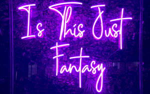紫色霓虹燈牌，上面寫著「Is This Just Fantasy」，以黑暗的葉牆為背景。
