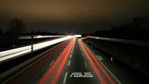 夜間高速公路，長時間曝光下紅色和白色車燈形成光軌。