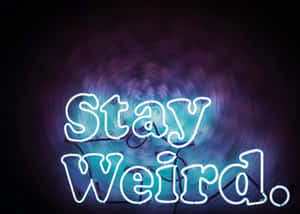 寫著「Stay Weird」的霓虹燈牌，帶有旋轉的紫色和藍色背景。