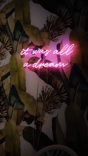 粉紅色霓虹燈牌，上面寫著 'it was all a dream'，在黑暗的熱帶葉子之間。