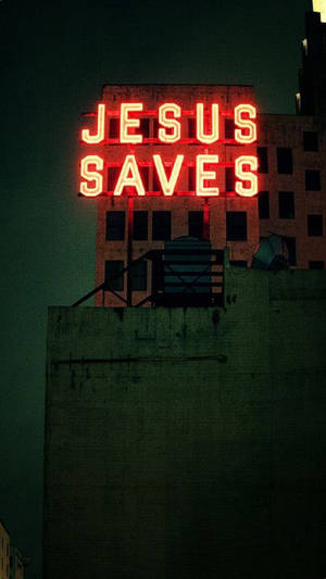 夜間城市建築物上寫著「Jesus Saves」的紅色霓虹燈牌。