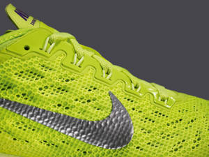 亮綠色Nike跑鞋，帶有銀色勾勾和網眼紋理。 — 綠色iPhone 壁紙