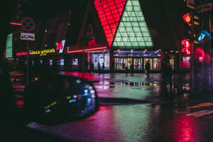 霓虹燈光在雨夜的城市中反射在濕漉漉的人行道上。
