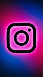 霓虹粉紅色Instagram標誌在藍紫色漸變背景上發光。