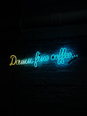 霓虹燈牌在深色磚牆上寫著 damn fine coffee