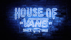 夜間磚牆上House of Vans的藍色霓虹燈牌。