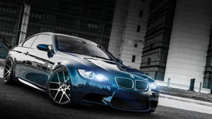 時尚的藍色BMW M3轎跑車夜間停在城市街道上，頭燈發光。 — 酷車 壁紙
