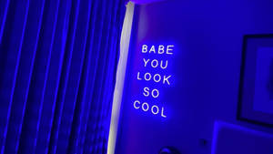 霓虹燈牌寫著 babe you look so cool，喺一個藍色燈光嘅房間。