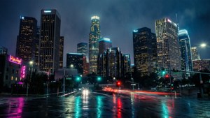 雨夜城市景觀，發光的摩天大樓和濕漉漉的街道反射著霓虹燈光。