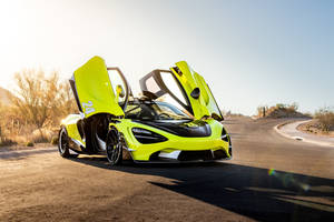 青檸綠色McLaren跑車，鷗翼車門打開，在日落時分的沙漠公路上。 — 螢光黃 壁紙