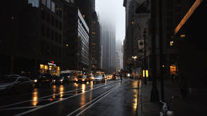 黃昏時分的城市街道，下雨，濕路面，霧濛濛的摩天大樓。