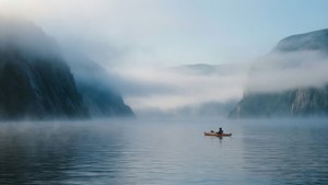 喺迷霧山峽灣黎明時分划皮划艇嘅人