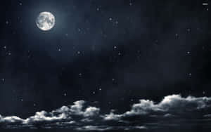 滿月在星空和柔雲上方發光。