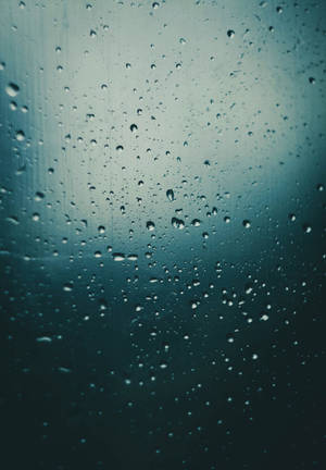 玻璃上的雨滴與模糊的青綠色天空背景 — Oppo Pad 5 壁紙