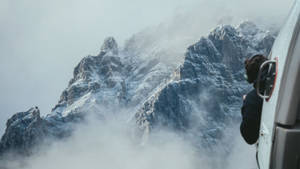 從直升機透過霧氣觀看雪山的人 — 電腦 GIF 壁紙