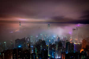 夜晚中發光的城市，摩天大樓從霧氣中浮現，天空呈紫色。