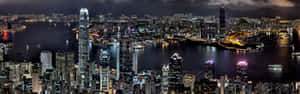 夜晚的香港天際線，燈火通明的建築和港口燈光。