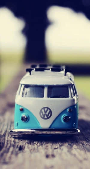 一架復古藍色和白色的VW貨車玩具在木質表面上。