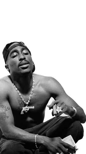 Tupac Shakur 赤裸上身坐著，閉上眼睛，戴著鏈條和帽子。