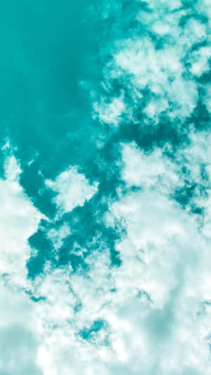 藍綠色天空，蓬鬆的白雲在平靜開闊的大氣中飄移。