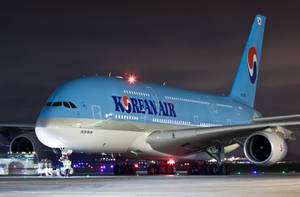 夜間機場停機坪上的大韓航空空中巴士A380與明亮燈光。